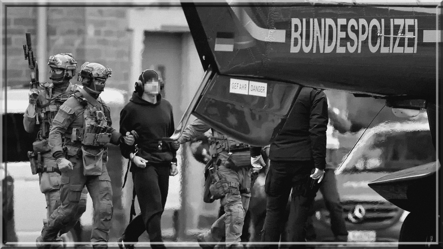 Ginkluoti specialiųjų pajėgų pareigūnai lydi sulaikytą vyrą prie Bundespolizei sraigtasparnio